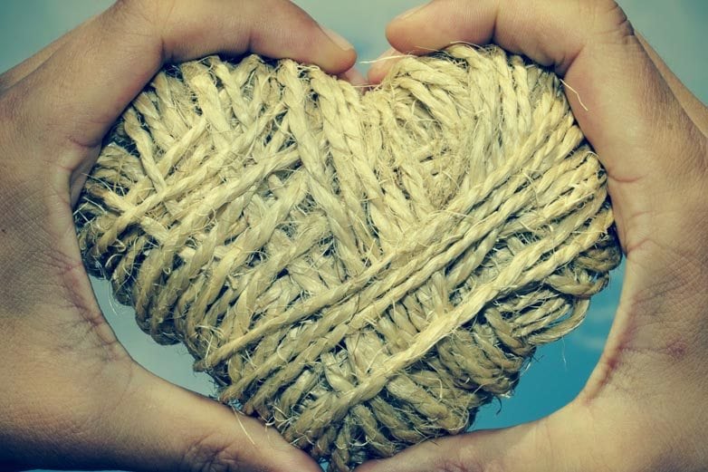 man hands forming a heart showing a heart-shaped coil of rope