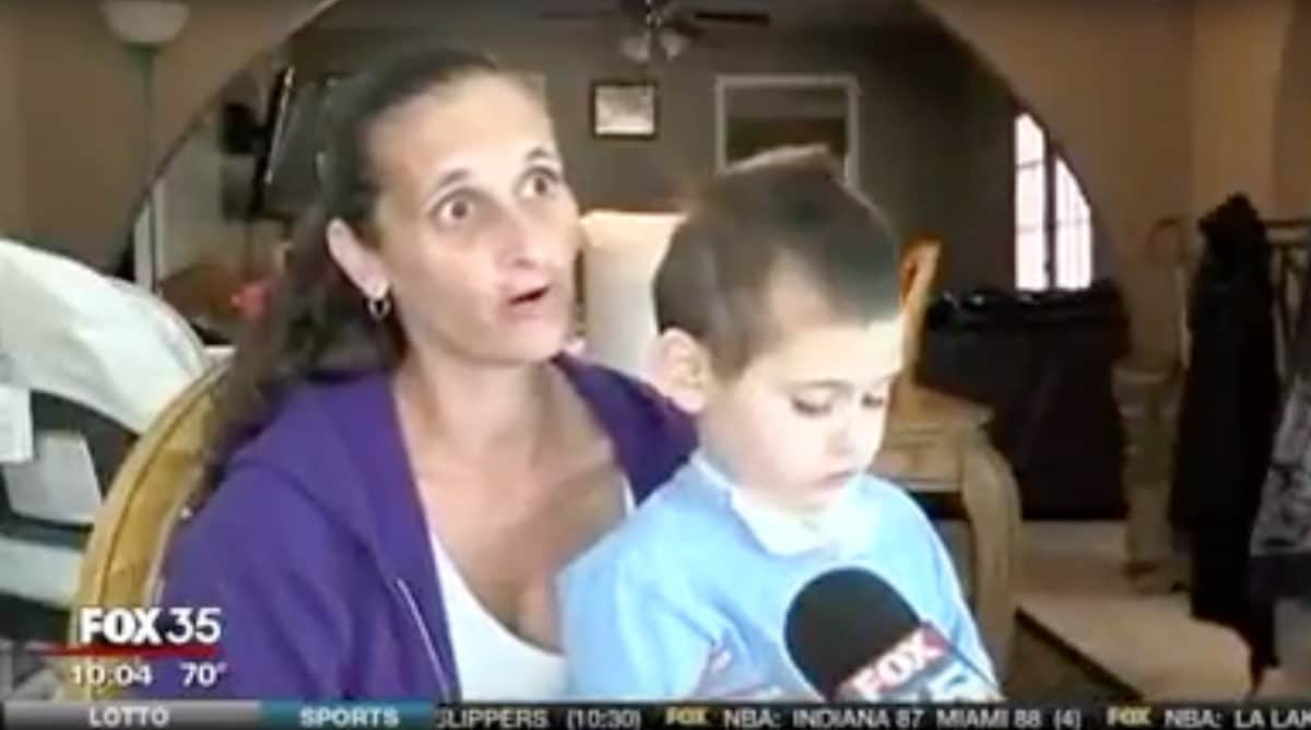 Woman and a young boy interviewed at home with a Fox 35 news microphone