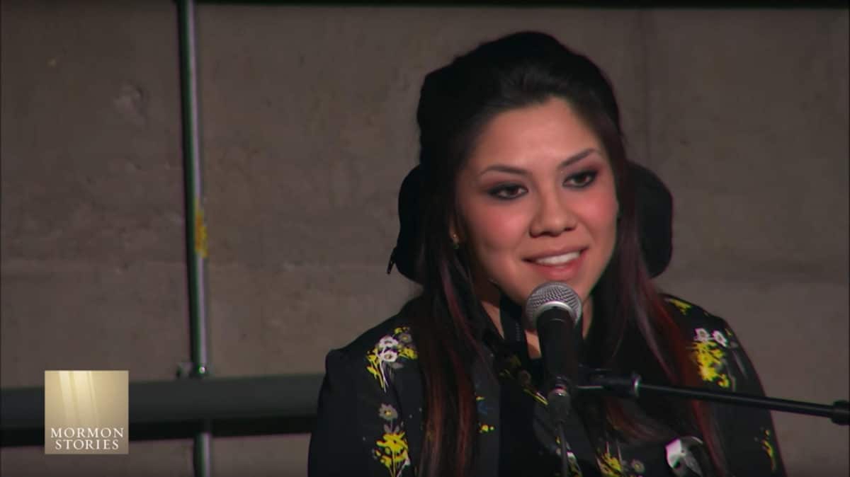 Woman speaking into a microphone at a Mormon Stories event