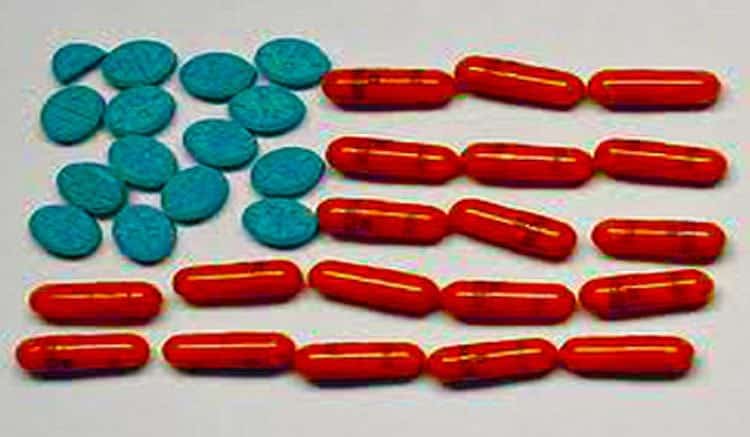 Blue pills and red gel capsules arranged as an American flag on a white background