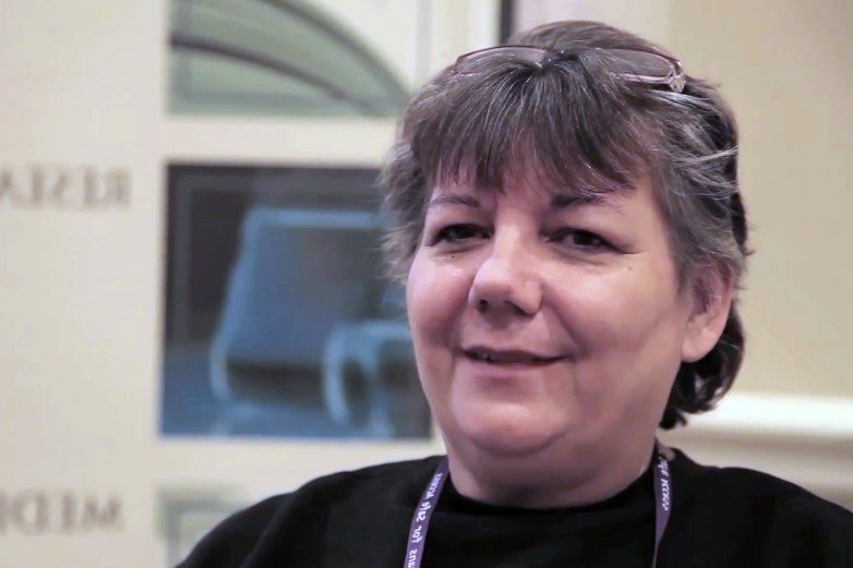 Woman with glasses on her head smiling during an interview at a medical cannabis event