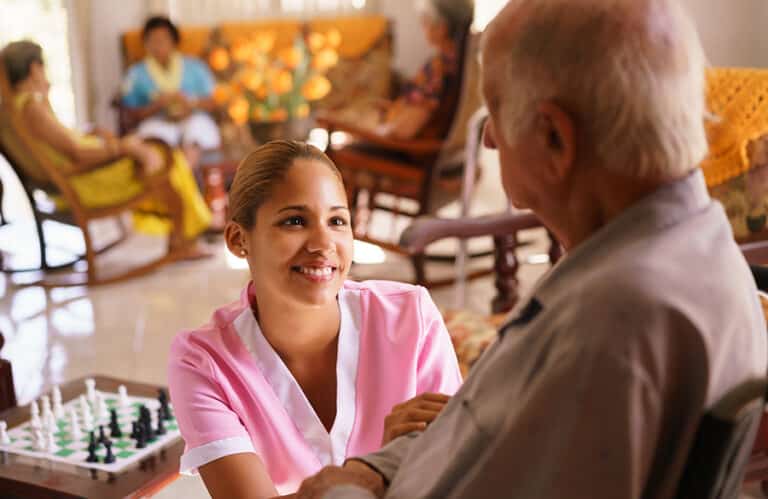 Hospice nurse helping an elderly man in a wheelchair